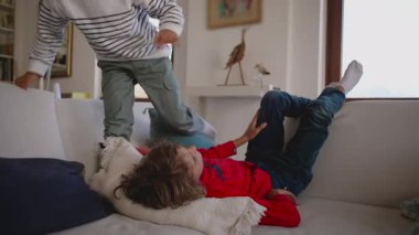 Bir çocuk koltukta huzurlu bir şekilde dinleniyor. Oturma odasında huzur ve sükunetin tadını çıkarıyor. Doğal ışık evi doldururken.