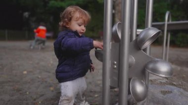 Yeni yürümeye başlayan bir çocuk ellerine kum topluyor ve onu oyun parkının metal tekerleğine serpiyor, sonra da taneciklerin nasıl dağılıp düştüğünü görmek için yapıyı dikkatlice döndürüyor. Değişen hareketi merakla izliyor, yerçekimi ile ilgili deneyler yapıyor.