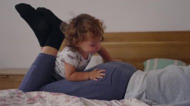 Yürümeye başlayan bir çocuk annesinin sırtına tırmanıyor, bir anlığına dengeyi sağlamaya çalışıyor, sonra içten ve sevecen bir aile etkileşiminin içine düşüyor sıcaklık ve neşe dolu bir enerjiyle