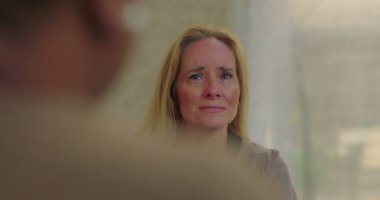 Grup terapisi sırasında duygularıyla konuşan bir kadın derin üzüntü ve hassasiyetini dile getirirken aynı zamanda iyileştirici uzayda destekleyici akranlarıyla iletişim kuruyor.