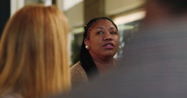 Terapi seansı sırasında grupla konuşan, akranlarıyla yüzleşen ve açıklık ve güven anında duygusal deneyimi paylaşan bir kadın.