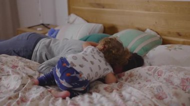 Anne ve bebek, sabahın erken saatlerinde yan yana dinlenerek anne-baba ve çocuk arasında içtenlik, yumuşaklık ve doğal sevgiyle dolu samimi bir aile anı yaratıyorlar.