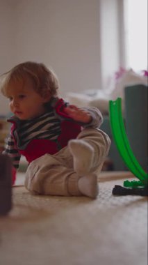 Genç çocuk, çömelme pozisyonundan ayakta durmaya geçerek fiziksel büyüme koordinasyonunu ve evde bağımsız hareketi ifade eder