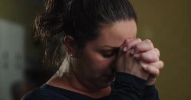 Kadınlar içeride başlarını eğip dua ederler, Tanrı 'ya olan güvenlerini ifade ederler, duygusal rahatlama, iç mücadele, ve zor zamanlarda yol gösterme umudu.