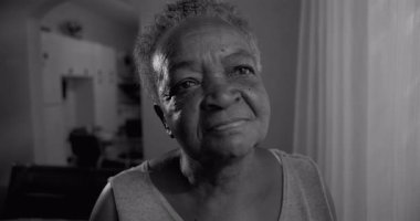 Kıdemli kadın kameraya siyah beyaz bakıyor, bilgeliğini, kabulünü, iç gücünü ve hayat boyu süren tecrübesini ifade ediyor.