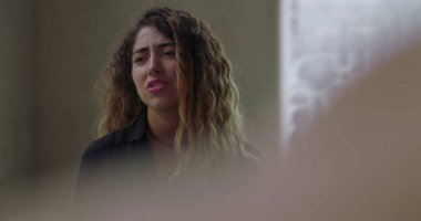 Grup terapisinde konuşurken duygulanan genç kadın, destekleyici ve önyargısız ortamda zor bir deneyim yaşarken gözleri kapalı