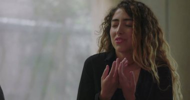 Grup terapisinde duygularıyla konuşan genç bir kadın hassas ve kişisel gerçekleri ifade ederken özenli ve destekleyici grup üyeleri etrafını sardı.