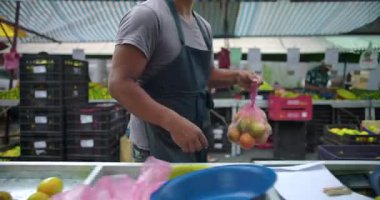 İspanyol satıcı taze ürünler taşıyor ve sokak pazarına bırakıyor. Hazırlık alışverişi ve pratik mahalle gıda ticareti yapıyor.