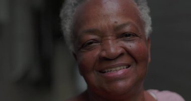 Dışarıda gülümseyen yaşlı Afrikalı Amerikalı kadını yakından çek. Duygusal rahatlama, pozitiflik ve yaşam tecrübesinden sonra sessiz bir memnuniyet.