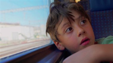 Delikanlı, trenin penceresinden dışarı bakıyor. Geniş gözlü, derin yüzlü, kolları pervazda dinleniyor. Gün ışığında geçen izler gibi bulanık.