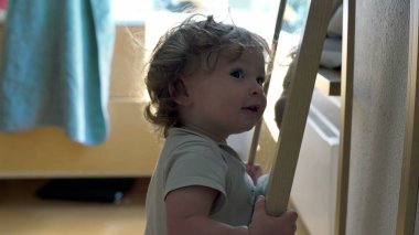 Bebek aynaya tutunarak ve yüzeye yakın eğilerek dengeyi korurken, her gün kapalı alanda keşif ve erken motor geliştirme anı