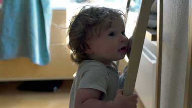 Bebek aynaya tutunarak ve yüzeye yakın eğilerek dengeyi korurken, her gün kapalı alanda keşif ve erken motor geliştirme anı