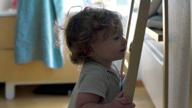 Bebek aynaya tutunarak ve yüzeye yakın eğilerek dengeyi korurken, her gün kapalı alanda keşif ve erken motor geliştirme anı