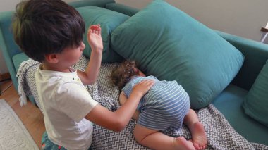 Ağabeyi, çocuklar arasında rahat bir ev ortamında birlikte yatarken, küçük kardeşlerine şakalar yaparak dokunuyor.