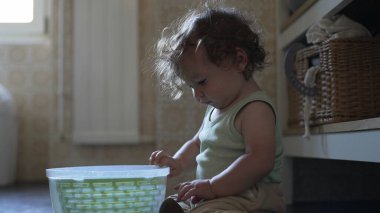 Bebek, mutfak zemininde otururken salata fırıldağı kapağını çevirirken görülmüş. Keşiflerin ilk aşamaları ve kendi kendine başlatılan oyun.