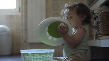 Bebek, mutfak zemininde otururken salata fırıldağı kapağını çevirirken görülmüş. Keşiflerin ilk aşamaları ve kendi kendine başlatılan oyun.