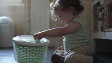 Bebek, mutfak zemininde otururken salata fırıldağı kapağını çevirirken görülmüş. Keşiflerin ilk aşamaları ve kendi kendine başlatılan oyun.