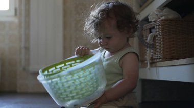 Bebek, mutfak zemininde otururken salata fırıldağı kapağını çevirirken görülmüş. Keşiflerin ilk aşamaları ve kendi kendine başlatılan oyun.
