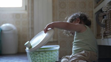 Bebek, mutfak zemininde otururken salata fırıldağı kapağını çevirirken görülmüş. Keşiflerin ilk aşamaları ve kendi kendine başlatılan oyun.