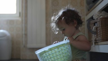 Bebek, mutfak zemininde otururken salata fırıldağı kapağını çevirirken görülmüş. Keşiflerin ilk aşamaları ve kendi kendine başlatılan oyun.