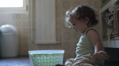 Bebek, mutfak zemininde otururken salata fırıldağı kapağını çevirirken görülmüş. Keşiflerin ilk aşamaları ve kendi kendine başlatılan oyun.