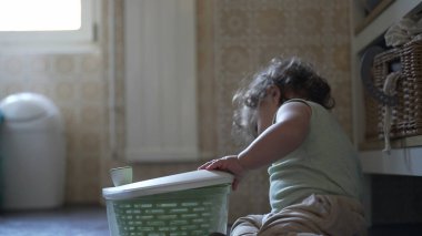 Bebek, mutfak zemininde otururken salata fırıldağı kapağını çevirirken görülmüş. Keşiflerin ilk aşamaları ve kendi kendine başlatılan oyun.