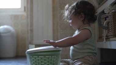 Bebek, mutfak zemininde otururken salata fırıldağı kapağını çevirirken görülmüş. Keşiflerin ilk aşamaları ve kendi kendine başlatılan oyun.