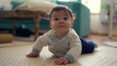 Bebek mindere uzanıyor, baş aşağı dinleniyor, sakin ve rahat, oyun sırasında mola veriyor, rahat konum, ev ortamı, huzurlu ve huzurlu an