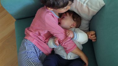 Ağabeyim bebeği kanepeye yakın tutuyor, rahatlıyor ve sarılıyor, kardeşlerim rahat bir evde birbirlerine bağlanıyor, sevgi ve özen gösteriyorlar.