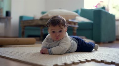 Bebek karnında, üst gövdesini kaldırıyor, kameraya gülümsüyor, oyuncu ve nişanlı, ev dekorasyonu, bebek gelişimi, mutlu bebek keşfi çevresi, meraklı ve özenli