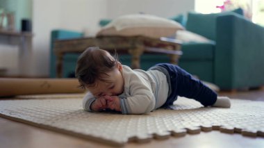 Bebek karnında, üst gövdesini kaldırıyor, kameraya gülümsüyor, oyuncu ve nişanlı, ev dekorasyonu, bebek gelişimi, mutlu bebek keşfi çevresi, meraklı ve özenli