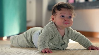 Bebek paspasın üzerinde yatarken gülümsüyor ve vücudu kaldırıyor, erken gelişimle meşgul oluyor, kapalı bir ortamda midede mutluluk ve merakı gösteriyor.
