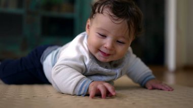 Bebek karnının üstünde yatar, çevreyi keşfeder, başını çevirir, eller yere açılır, emeklemenin ilk aşamaları, ev ortamı, bebek gelişimi, meraklı ve ilgili bebek