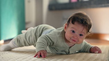 Bebek paspasın üzerinde yatarken gülümsüyor ve vücudu kaldırıyor, erken gelişimle meşgul oluyor, kapalı bir ortamda midede mutluluk ve merakı gösteriyor.
