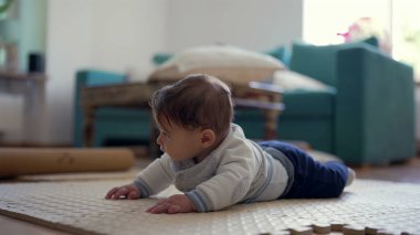 Bebek karnında, üst gövdesini kaldırıyor, kameraya gülümsüyor, oyuncu ve nişanlı, ev dekorasyonu, bebek gelişimi, mutlu bebek keşfi çevresi, meraklı ve özenli