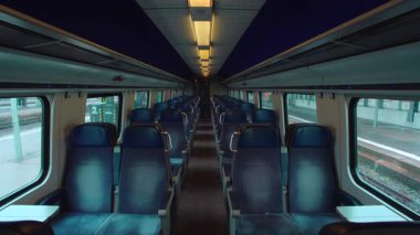 Yolcu vagonu, yolculuğun başlamasına dakikalar kala istasyonda boş duruyor. Sessizlik sağlanıyor. Her gün ulaşım ritmi ve geçici kamu alanı havası.