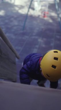 Küçük çocuk, güven, motor becerisi geliştirme ve park ortamında maceralı öğrenme gibi el kaldırarak oyun yapısının basamaklarını tırmandı