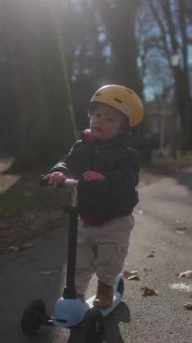 Küçük çocuk miğfere dokunurken ve gidonu tutarken duraksıyor. Bu da merak dengesini ve erken çocukluk davranışlarını yansıtıyor.