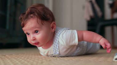 Bebek karnına kafa kaldırma, çevreyi keşfetme, erken gelişim kilometre taşı, odaklanmış ifade, yerde midelerin keyfini çıkarma, konforlu ev ortamında motor becerisi gelişimi