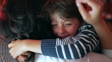 Ağlayan çocuk duygusal bir anda annesine yapışır. Huzur ararken, ellerini sallayarak, üzüntüsünü ve aile bağını ifade ederken, yakınlaşırken.