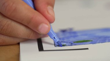 Mavi kalemle çocuğun el boyaması, hassasiyete, yaratıcılığa ve sanatsal ifadeye odaklanıyor