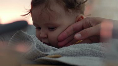 Beyaz tabağa bakan bebek, yoğun odaklanma, dokunsal keşif, yüksek bir sandalyede oturmak, yemek sırasında merakını ve erken gelişim davranışlarını gösterir.