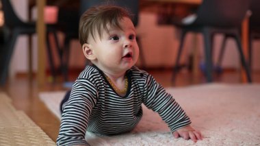 Bebek kollara dayanıyor, meraklı bir ifadeyle gözleri açık, mideye dalıyor, erken gelişim aktivitesi, ev ortamında dayanıklılık ve koordinasyon sağlıyor.