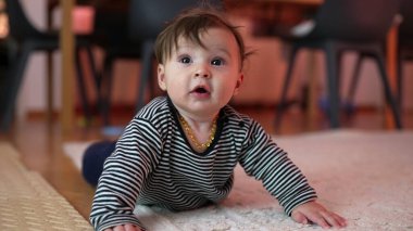 Bebek kollara dayanıyor, meraklı bir ifadeyle gözleri açık, mideye dalıyor, erken gelişim aktivitesi, ev ortamında dayanıklılık ve koordinasyon sağlıyor.