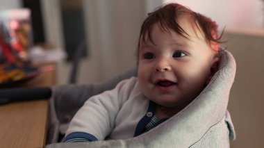 Bebek sevinçle gülerken minderli sandalyeye yaslanıyor, saf mutluluk, geniş gülümseme, neşeli ifade, neşeli enerji, çocukluk sevincinin doğal anı