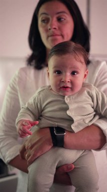 Anne kucağında baş parmak emen bir bebek, konfor, bakım, yatıştırıcı jest, otantik ebeveyn-çocuk bağı, sıcaklığı ve sevgisi günlük aile hayatında