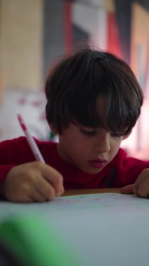Child holding pen and carefully completing worksheet, closeup education scene expressing attention, discipline and early academic development