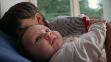 Ağabeyim bebeği yoğun bir şekilde öpüyor, sevecen ama ezici bir kardeş anı, çocukluk bağı, yakınlık, aile sevgisi, koruyucu kucaklama, duygusal bağ.