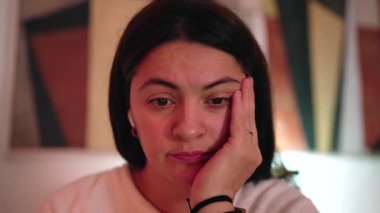 Intimate front view of female professional absorbed in computer task, subtle expression suggesting concentration, tiredness and steady productivity indoors