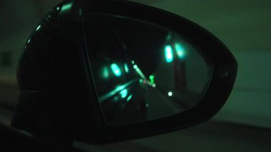 Aydınlatılmış tünel duvarları ve yol işaretlerinin otomatik ayna görüntüsü, hareketin ve derinliğin vurgulandığı dinamik seyahat anı